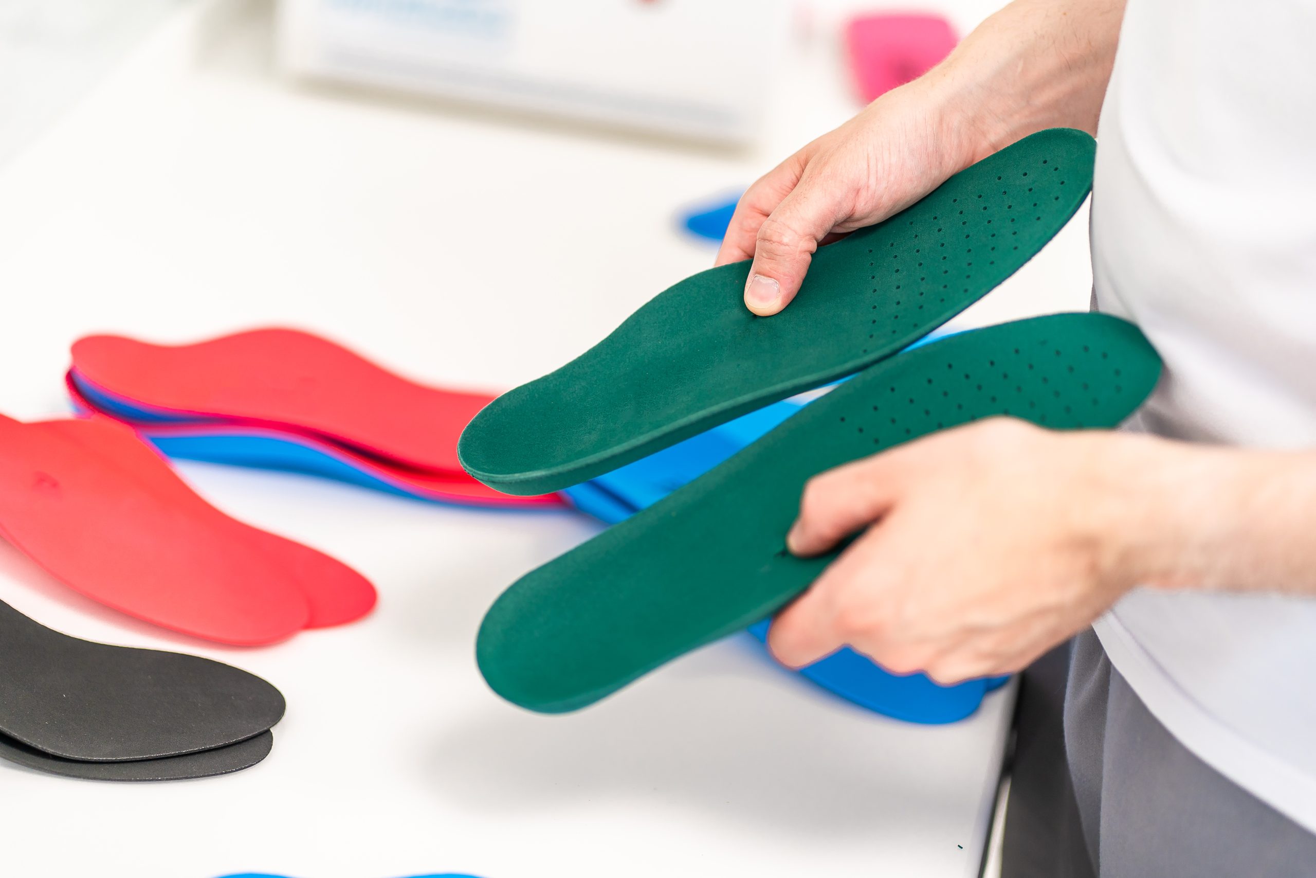 Orthopedic insole. The orthopedist works with the patient. Orthopedic clinic. Choice of insoles in an orthopedic clinic. The orthopedist offers the insole to the patient Foot care