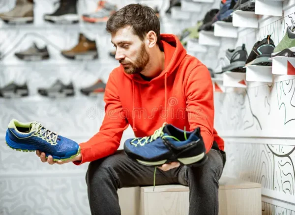 man-choosing-hiking-shoes-shop-trail-sitting-fitting-room-modern-sports-136782386