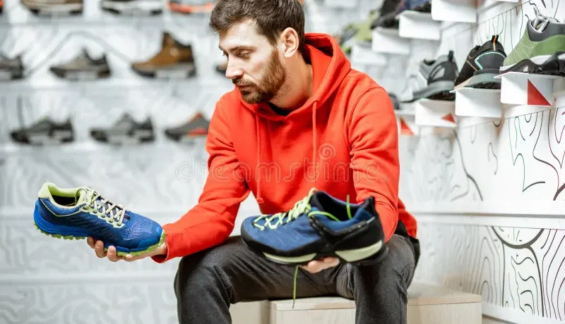 man-choosing-hiking-shoes-shop-trail-sitting-fitting-room-modern-sports-136782386